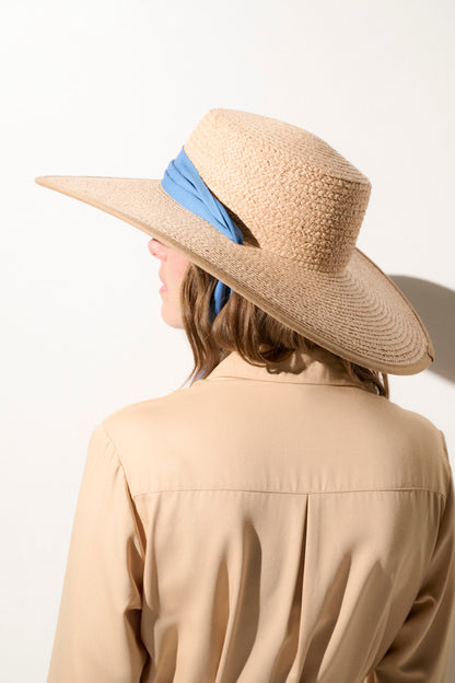 Chapeau anti-UV femme beige avec un foulard bleu, parfait pour une protection solaire élégante en extérieur.