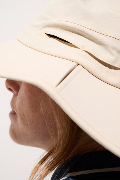 Chapeau anti-UV beige UPF50+ pour femme, léger et respirant, idéal pour le golf et les activités en plein air.