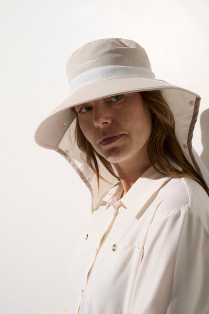 Chapeau anti-UV beige UPF50+ pour femme, offrant une protection solaire lors d'activités en extérieur.