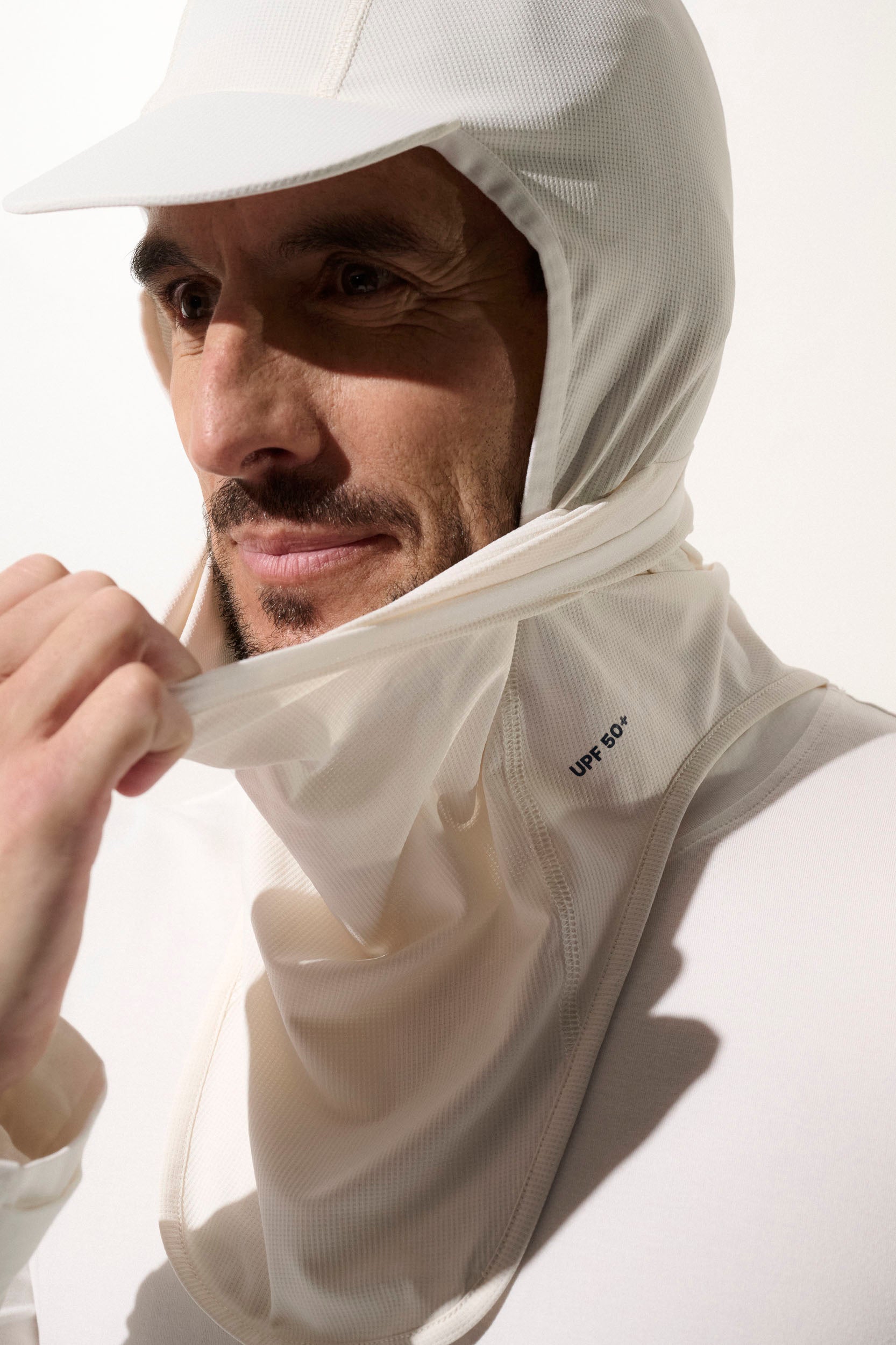 Cagoule anti-UV blanche pour homme, légère et respirante, offrant une protection solaire UPF 50+ pour activités extérieures.