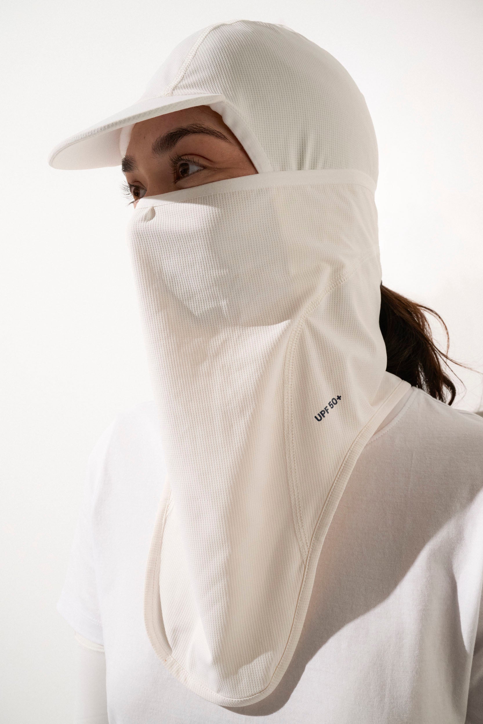 Cagoule visière anti-UV blanche UPF50+ pour femme, légère et respirante, idéale pour la protection solaire lors d'activités sportives.