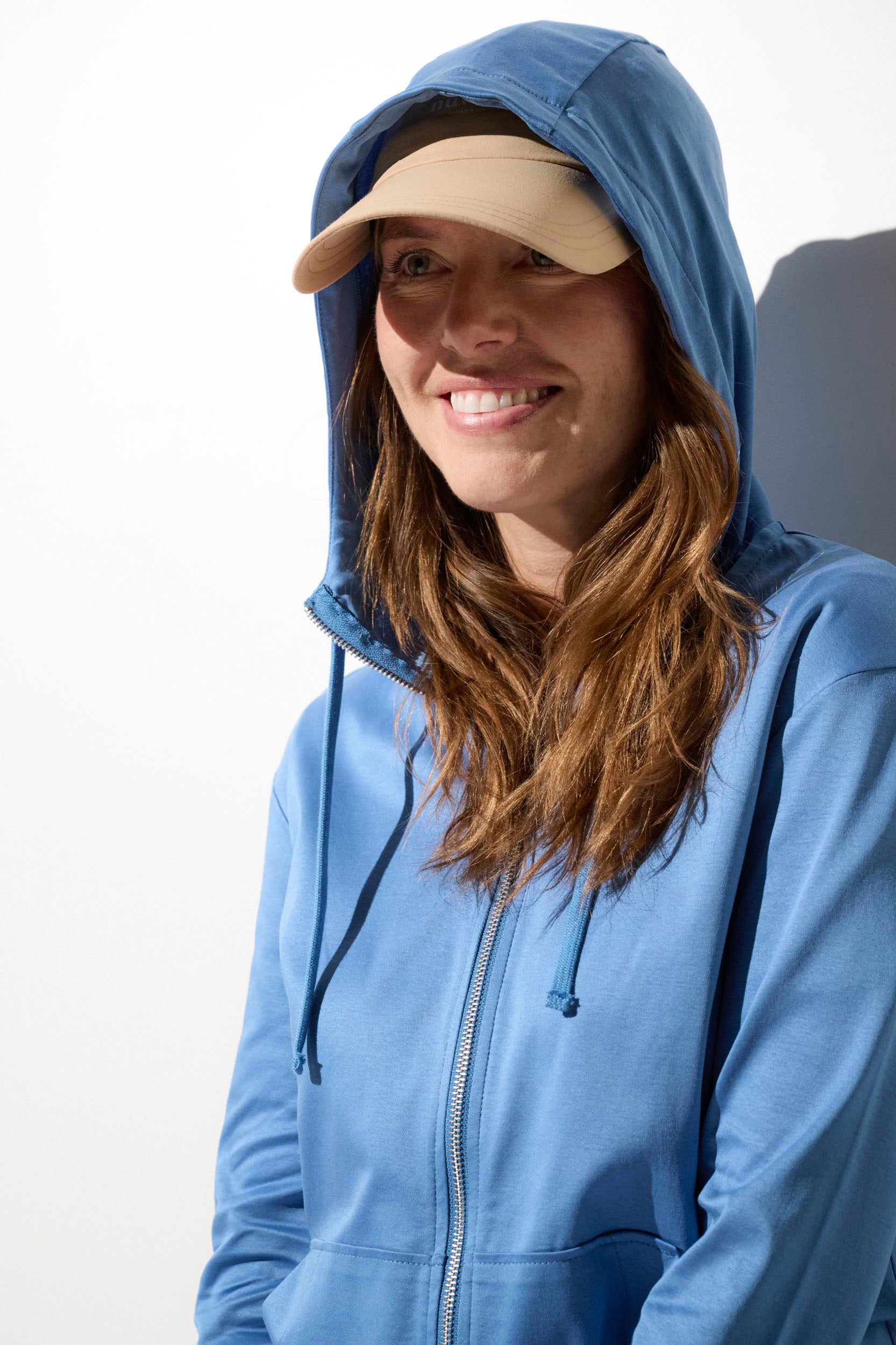 Sweat-shirt anti-UV bleu pour femme, capuche légère, offrant protection solaire UPF50+ lors des activités de plein air.