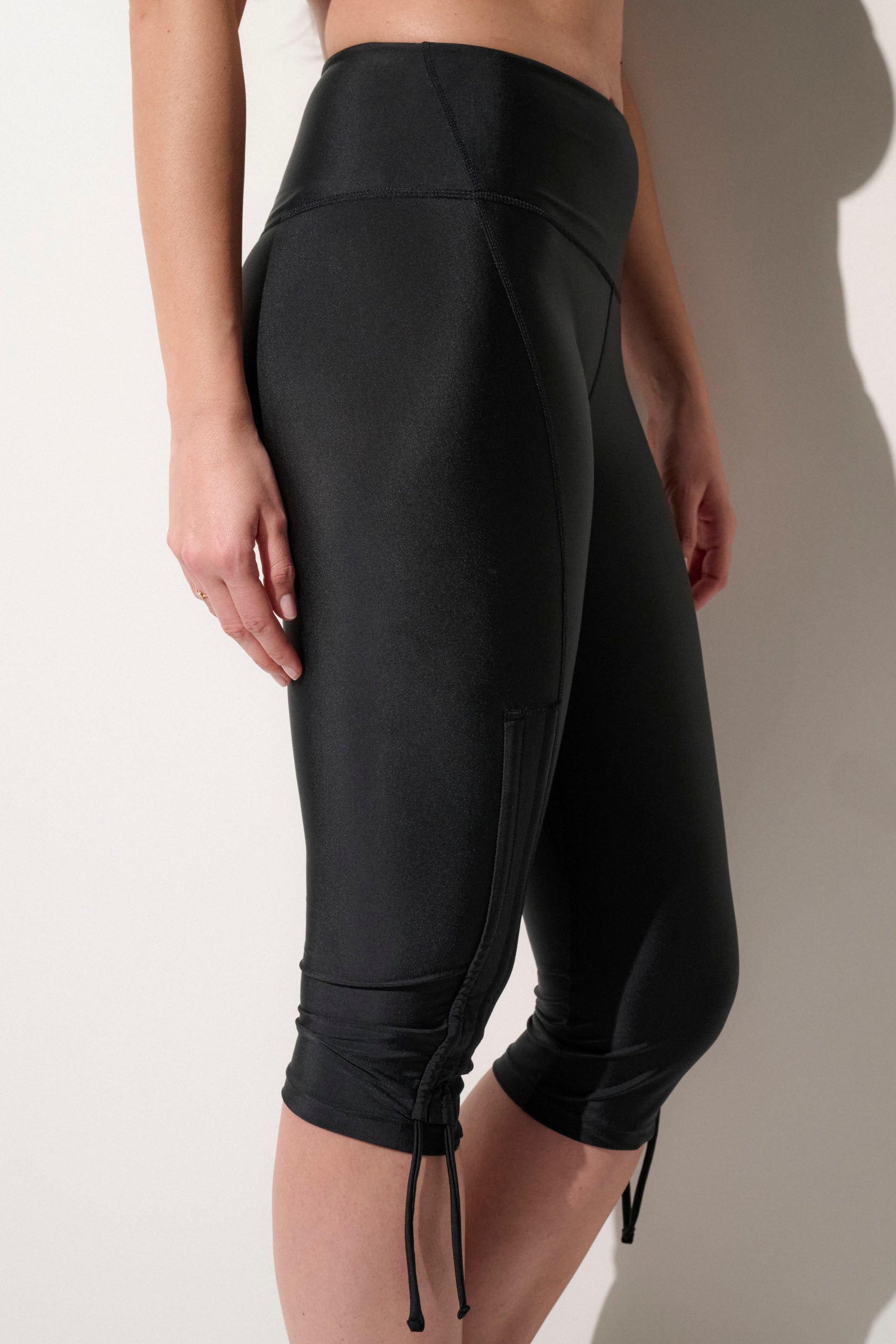 Leggings anti-UV noirs pour femme, coupe ajustée et tissu léger, parfaits pour le sport et la plage, certifiés UPF50+.