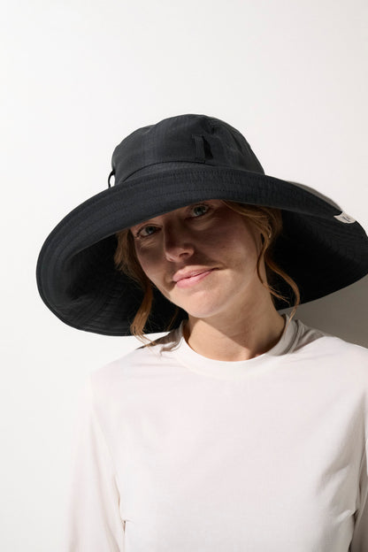 Chapeau anti-UV noir UPF50+ pour femme, idéal pour se protéger du soleil lors d'activités extérieures.