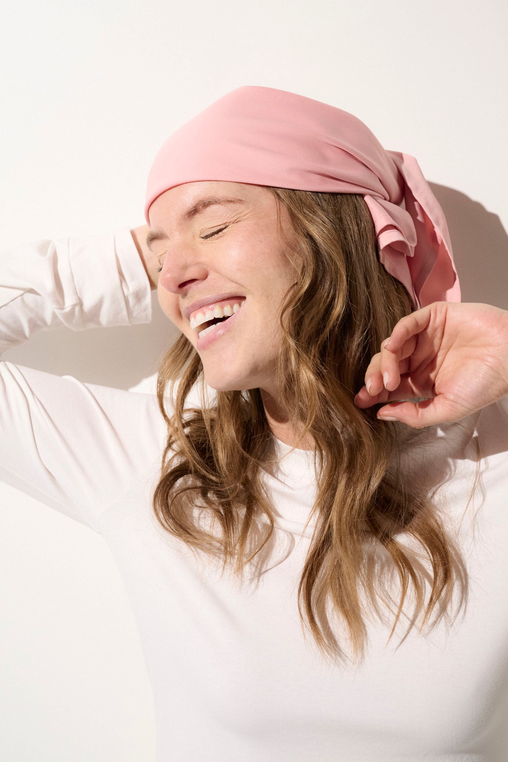 Foulard anti-UV rose pour femme, UPF 50+, porté avec élégance pour une protection solaire quotidienne.