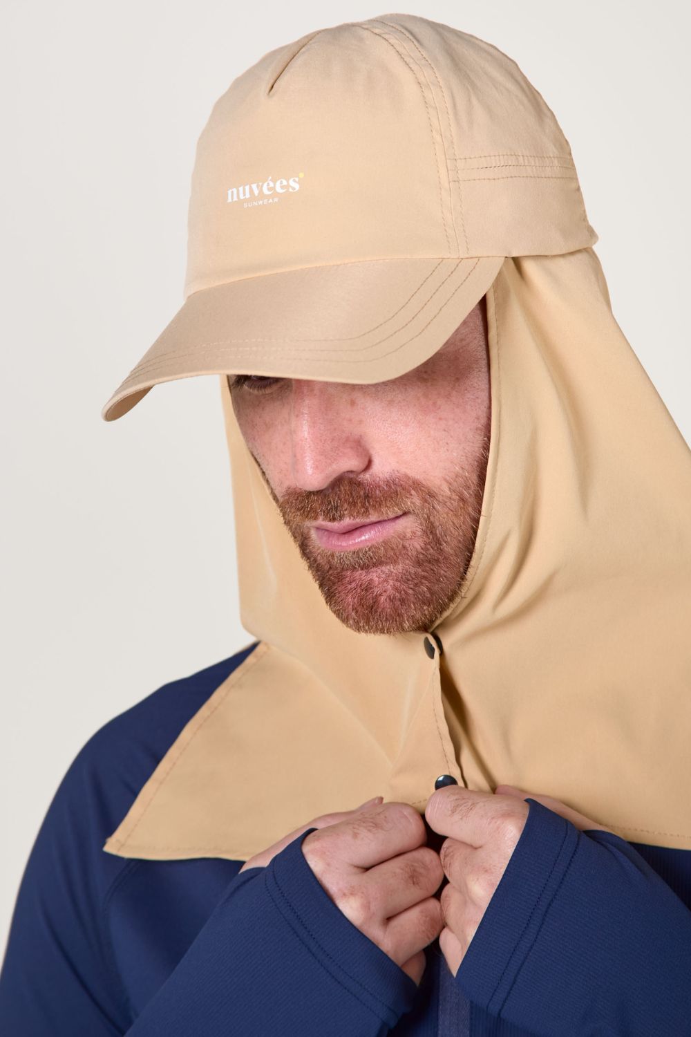 Casquette anti-UV beige avec protection solaire amovible, idéale pour les activités en plein air.