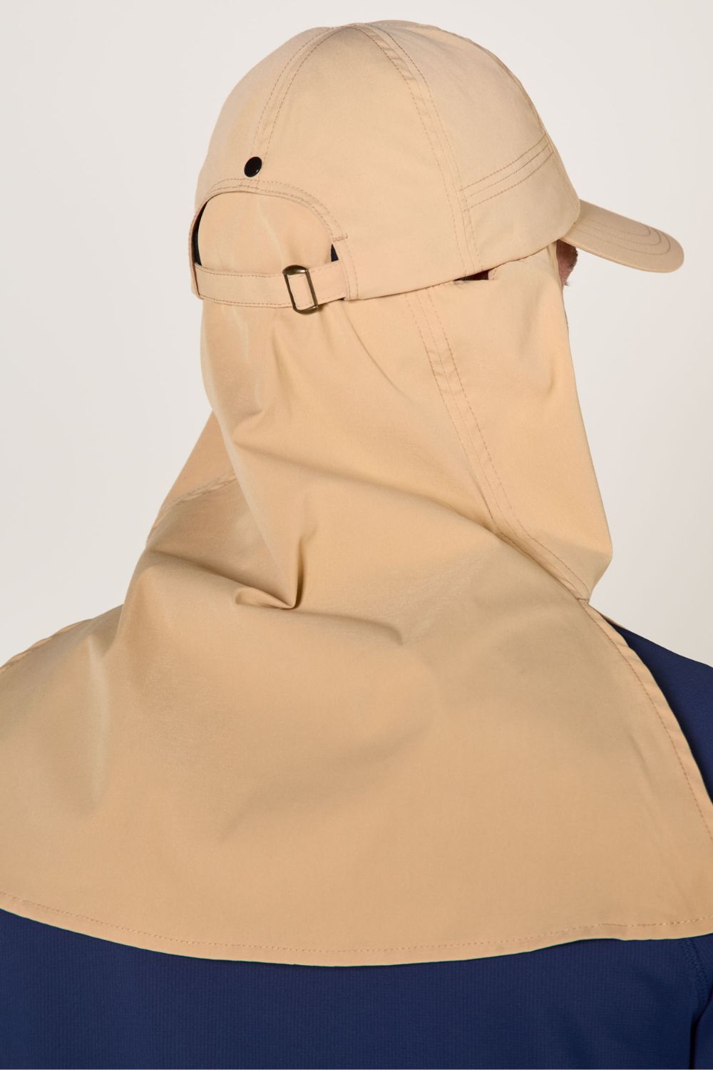 Casquette anti-UV beige avec protection solaire intégrée, idéale pour les activités de plein air.