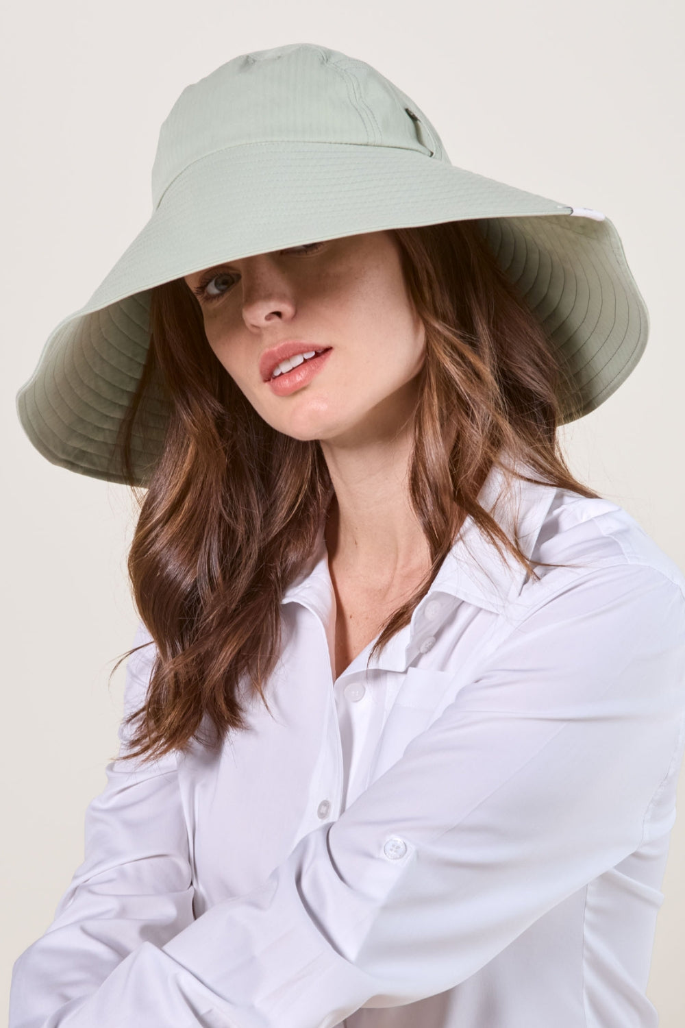 Chapeau anti-UV vert Herbe Fraîche sur femme, offrant une protection solaire élégante et confortable.