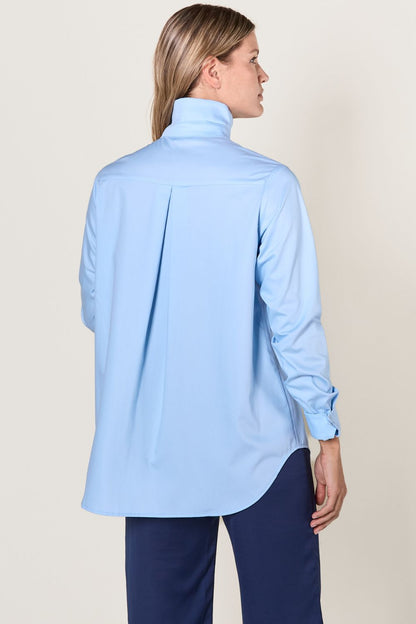 Chemise longue anti-UV bleue pour femme, coupe ample, protection solaire UPF50+ et élégante, manches retroussables.