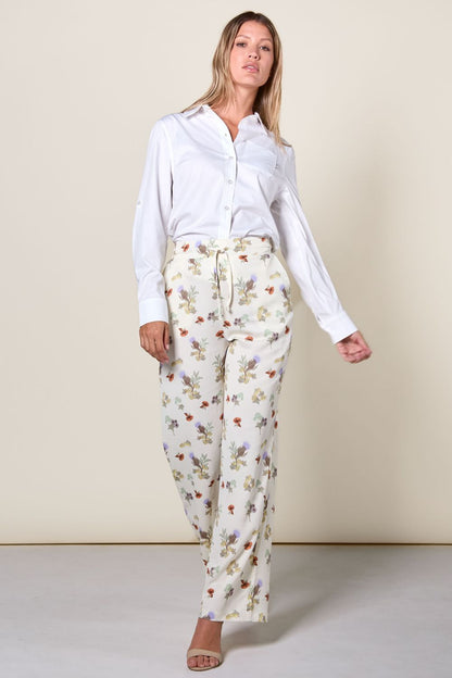 "Femme portant un pantalon anti-UV floral UPF 50+, léger et respirant, parfait pour les journées ensoleillées."